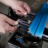 Hands adjusting a blue aluminum router table fence on woodworking equipment