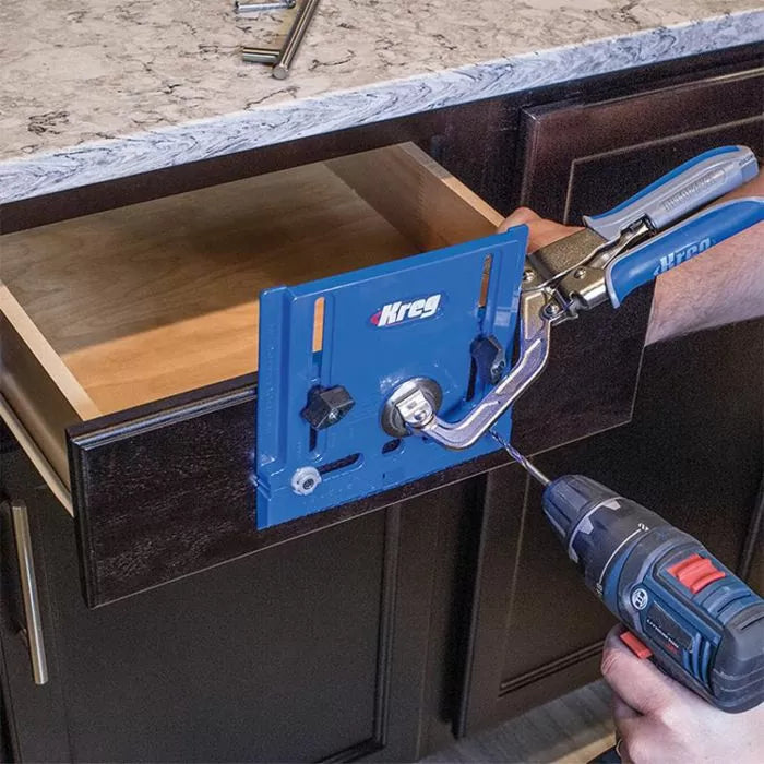 Drawer front installation jig clamped to cabinet drawer, guided by cordless drill