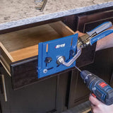 Drawer front installation jig clamped to cabinet drawer, guided by cordless drill