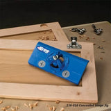 Blue concealed hinge jig tool on wooden cabinet doors with installed hinges, woodworking setting