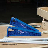 Kreg blue drawer slide jig set on woodworking table with metal drawer slides and wooden drawer box.