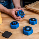 Blue woodworking bench cookies for gripping wood, shown on a workshop table by a carpenter