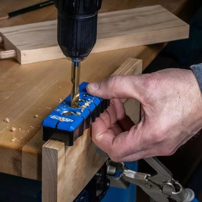 Hand using drill and pocket hole jig on wood for precise woodworking joints