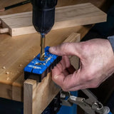 Hand using drill and pocket hole jig on wood for precise woodworking joints