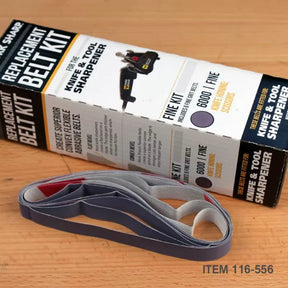Replacement belt kit for knife and tool sharpener with abrasive sanding belts on wood surface