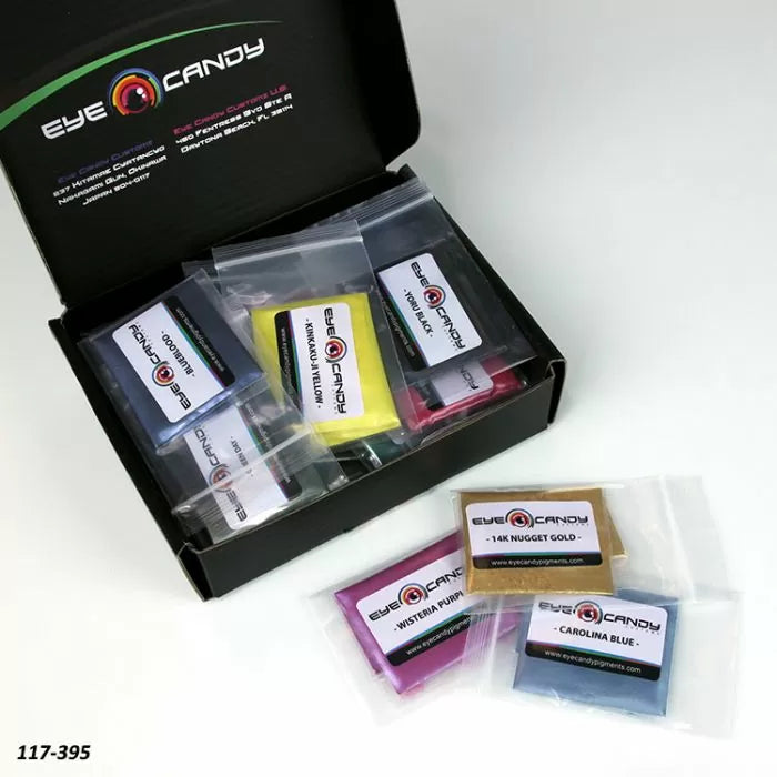 Assorted pigment powder sample packs in labeled bags displayed with open box on white background.