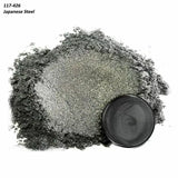 Fine Japanese steel powder with metallic texture and round black container on white background.