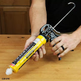 Person using a manual caulking gun with epoxy crack filler on a woodworking bench