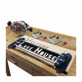 Woodworking router lettering jig on wood slab with clamps and router, carving sign.