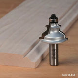 Woodworking router bit with decorative profile next to routed wood edge on workbench