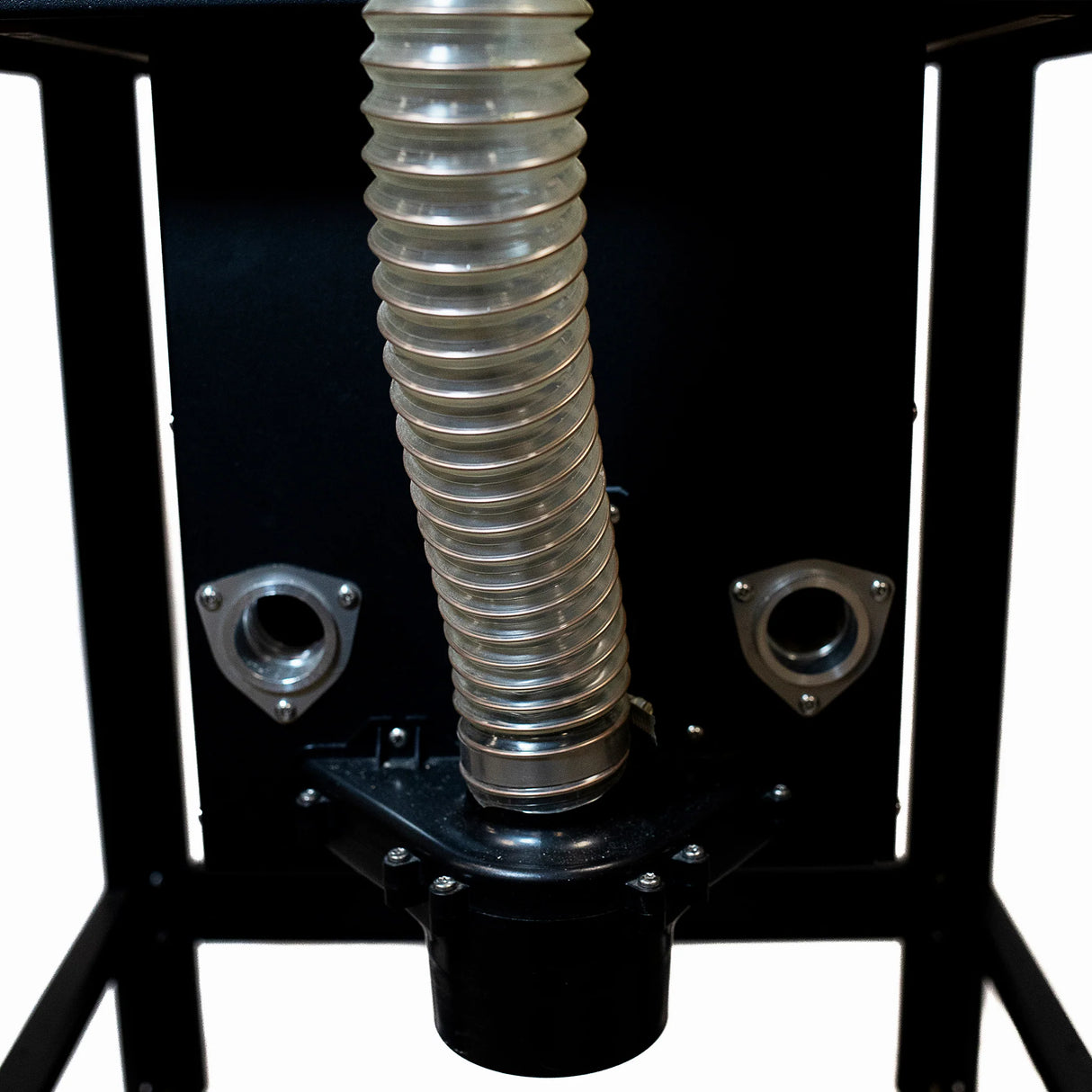 Clear flexible dust collection hose attached to woodworking router table base