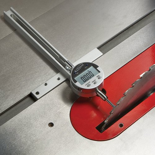 Digital gauge measuring alignment of table saw blade, woodworking tool on metal surface