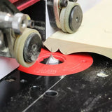 Wood router table setup with router bit cutting a decorative edge on wood piece