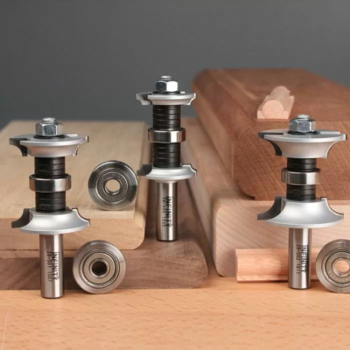 Woodworking router bits and bearings displayed with decorative wood molding pieces.