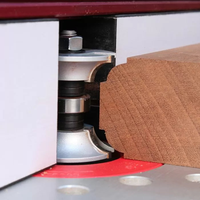 Woodworking router bit cutting decorative edge on hardwood board