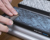 Hand stropping a plane blade on a 5000 grit blue wax honing stone for woodworking tool sharpening