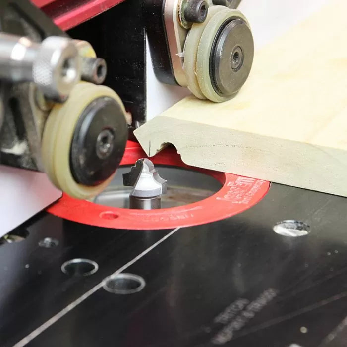 Router table with router bit shaping wood edge, woodworking tool in use