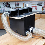 Router table dust collection box with clear flexible hoses in woodworking shop