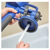 Person cleaning or assembling a blue handheld paint sprayer with a plastic tube