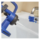 Blue handheld pressure sprayer nozzle with adjustable tip spraying water near a utility sink