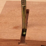 Threaded metal bolt in T-slot track on wooden woodworking jig