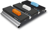 Three sharpening strops with orange, white, and blue wax bars for woodworking tools