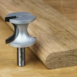 Large roundover router bit on wood table beside rounded edge hardwood board