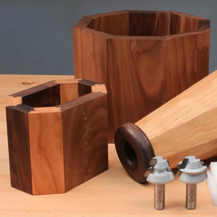 Wooden segmented turning blanks and two woodworking router bits on a workbench