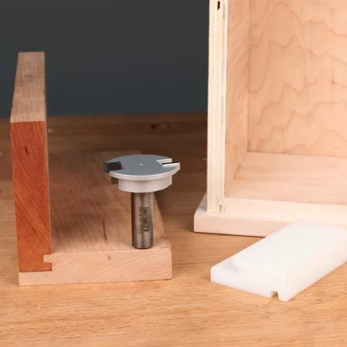 Woodworking router bit on table with joined wooden panels and plastic jig