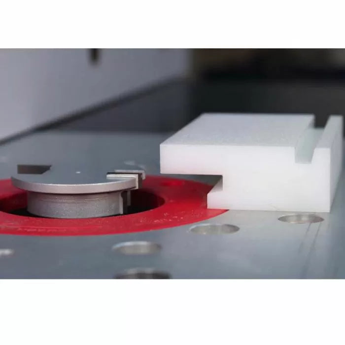 Router table setup with slot cutting router bit and white dado-cut sample