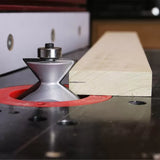 Router bit cutting profile on wood board on router table in woodworking workshop
