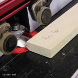 Router table with wood board marked 'Face Up,' cutting a precise woodworking edge.