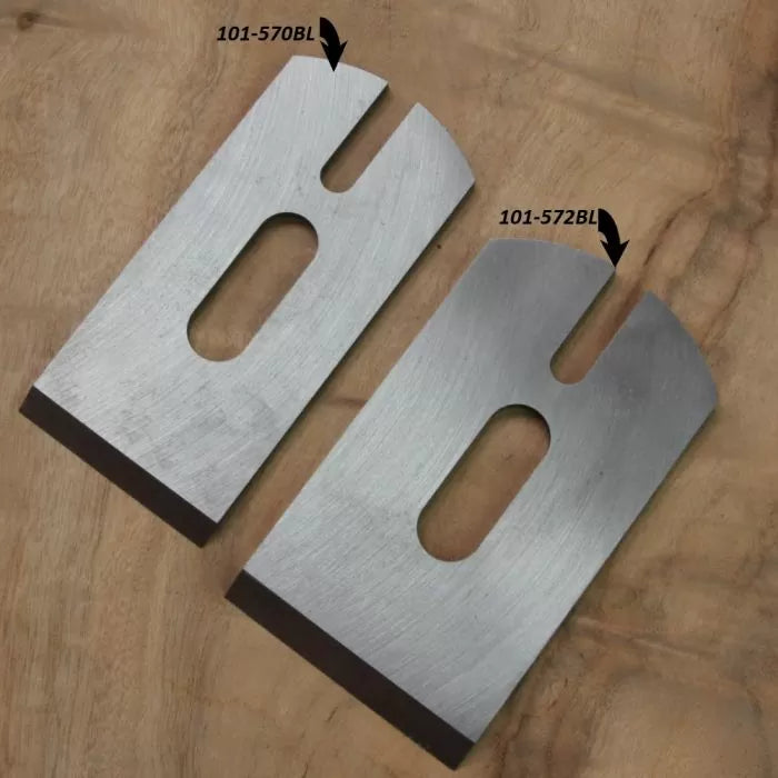 Two steel planer blades with identification labels on a wooden surface, woodworking tool accessories.