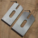 Two steel planer blades with identification labels on a wooden surface, woodworking tool accessories.