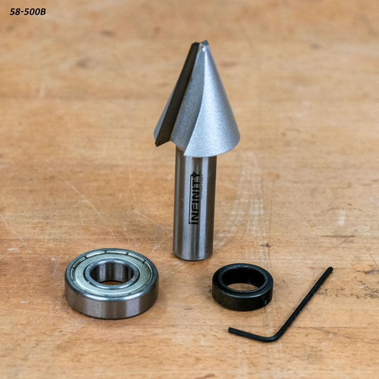 Chamfer router bit set with bearing, lock ring, and hex key on wooden surface
