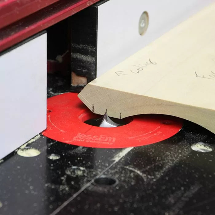 Woodworking router table in use, trimming wooden board with router bit and red insert ring