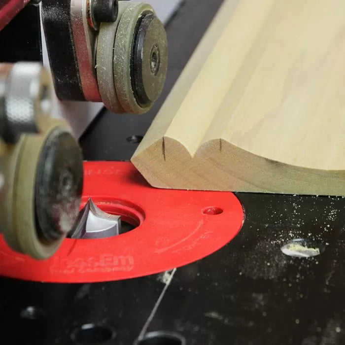 Woodworking router table in use shaping moulding with router bit and guide wheels