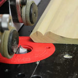 Woodworking router table in use shaping moulding with router bit and guide wheels