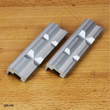 Aluminum dovetail track clamps on a wooden workbench for woodworking jigs and fixtures