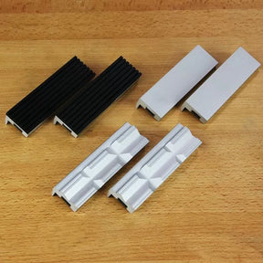 Set of six woodworking vise jaw pads with varied surfaces on a wood background