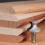 Roundover router bit with stacked wooden molding samples on a workbench for woodworking projects