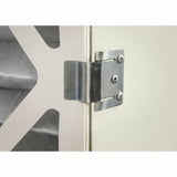 Close-up of metal hinge attached to a cabinet door, woodworking hardware detail
