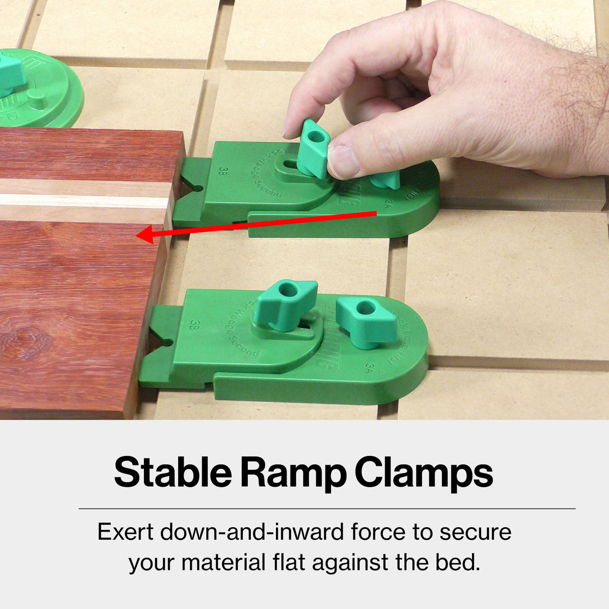 Hand adjusting green CNC ramp clamps securing wooden board on MDF worktable, woodworking tool setup.