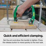 Woodworker using quick-action clamps to secure a board for sanding on a workbench.