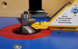 Close-up of woodworking router bit with setup gauge on blue router table surface