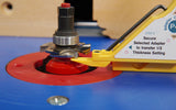 Close-up of a woodworking router bit and thickness setting jig on a router table.
