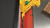 Table saw with red blade insert, yellow safety jig, and wood piece for precise woodworking