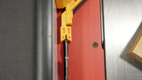 Close-up of table saw blade with yellow safety tool and wood piece on metal surface