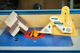 Router table with yellow gauge, joinery wood samples, and router bit for precision woodworking.