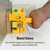 Close-up of a Grr-ripper push block guiding wood against a bandsaw fence for resawing.
